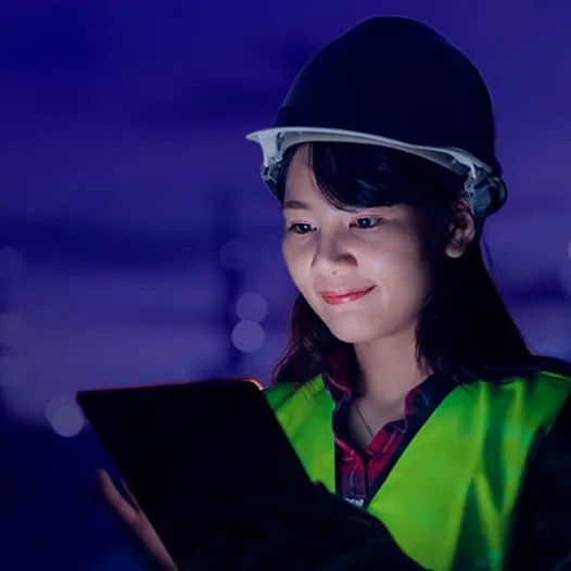 Woman wearing hard hat and holding tablet